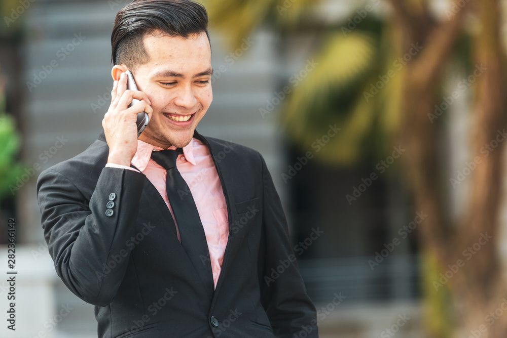 Young Malay Business Man talking on his Smartphone. Young Malay Business Man talking on his Smartphone.