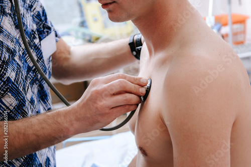 Doctor checks a patient using a stethoscope in the office hospital © thomsond