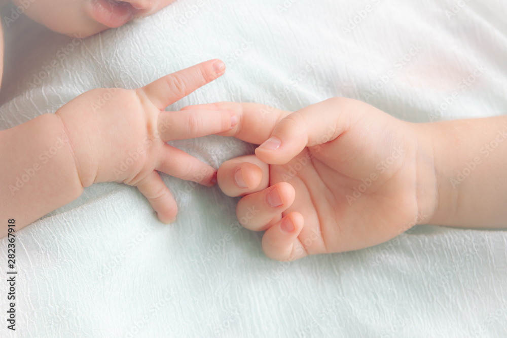 hands of the baby and little girl. two babies hands