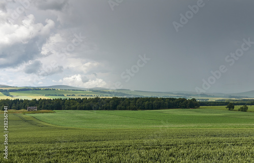 Bad Weather coming down the Strathmore Valley near Montrose on a Summers day, with Fields and an abandoned Farm Cottage about to get rained on.