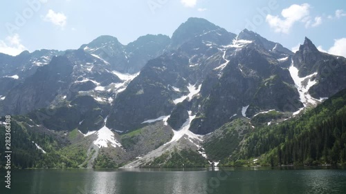 Still shot of the Tatra mountains with snow on summer and the lake of Morskie Oko.