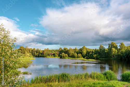 Rural landscape with a lake and a village. The middle strip of Russia.