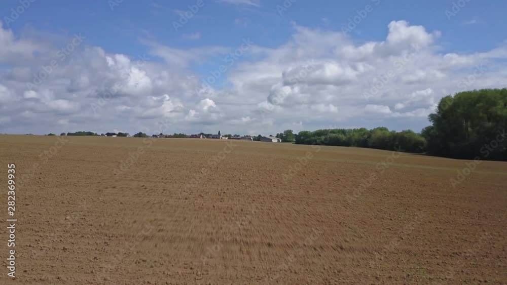 Backward travelling of a drone in direction of a city, above the fields Backward travelling of a drone in direction of a city, above the fields
