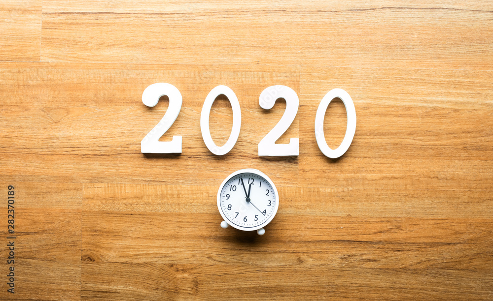 Celebration and countdown of new year 2020 concepts with text number and alarm clock on wood background Celebration and countdown of new year 2020 concepts with text number and alarm clock on wood background