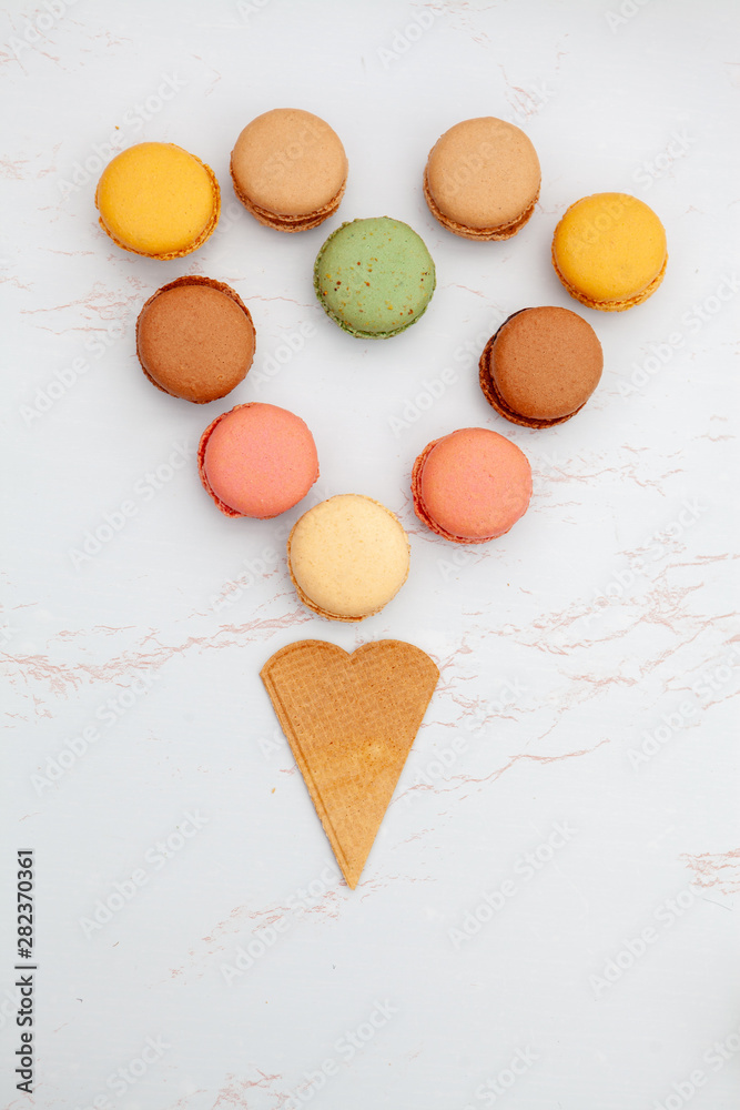 Fun flat lay composition of the colorful and sweet tasting small French cake macaron or macaroon combined with cookies Fun flat lay composition of the colorful and sweet tasting small French cake macaron or macaroon combined with cookies