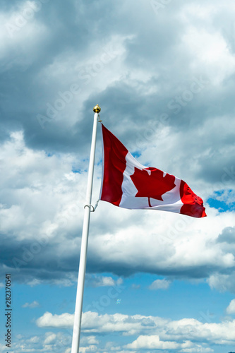 Canadian Maple Leaf national Flag flying over mountains