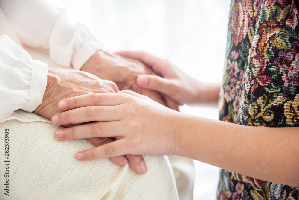 Close up of young girl holding senior hands ,Family care and support concept . Close up of young girl holding senior hands ,Family care and support concept .