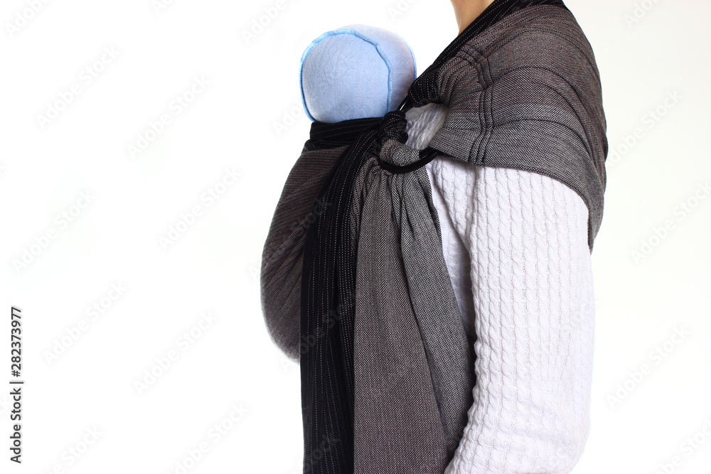 Obraz premium A newborn baby in a ringsling baby carrier in vertical position