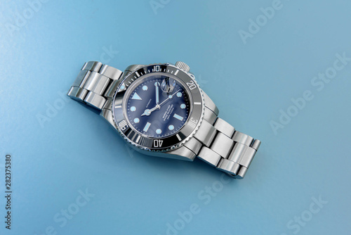 Big stainless steel sport divers watch on light blue background