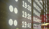 Modern departures board with detail on European cities destinations typed in illuminated letters at Schwechat airport, detail on display