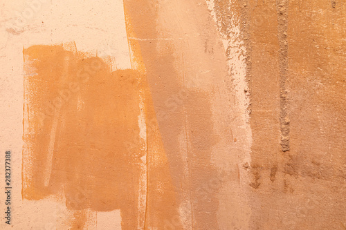 фотографія An orange unevenly painted beton wall