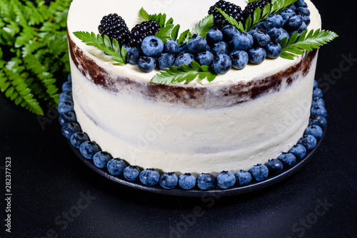 Beautiful tasty cake with white cream and berries of blueberry