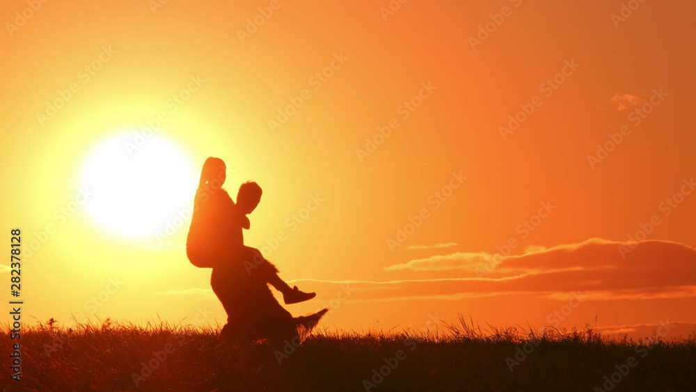young couple with playful dog fooling around at sunset in summer.