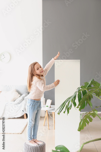 Cute little girl measuring ...