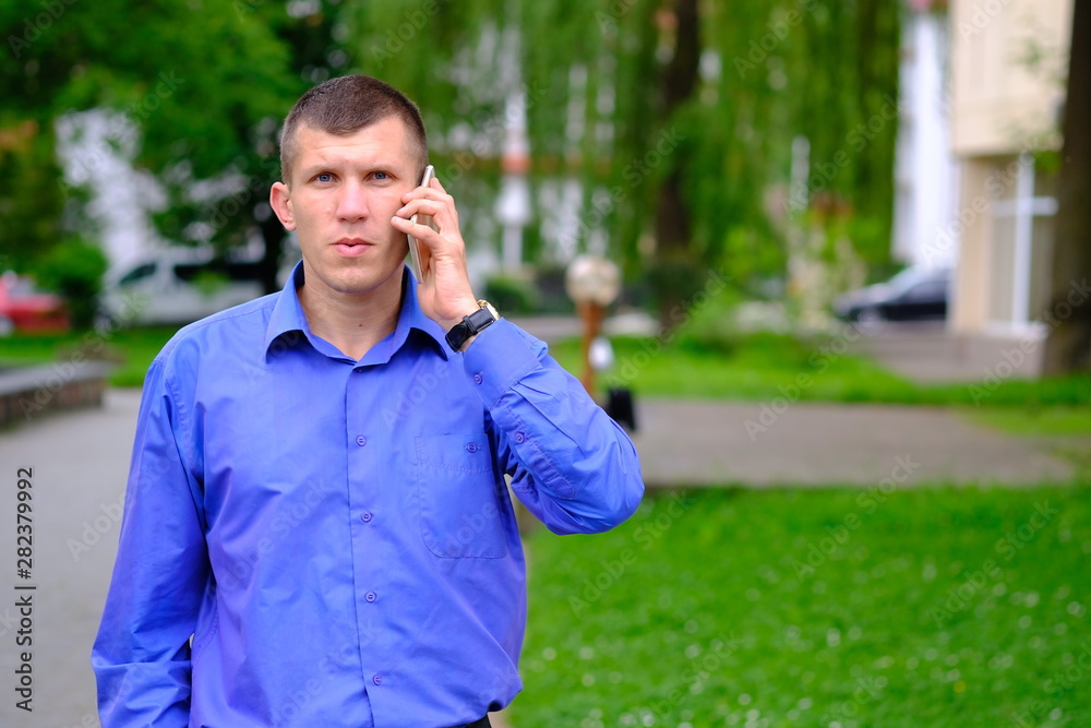 Confident seriously young man holding smartphone. Confident seriously young man holding smartphone.