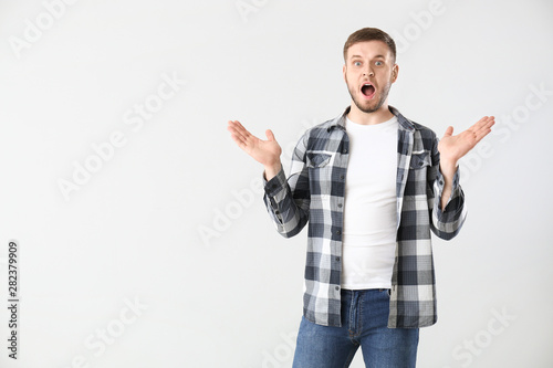 Shocked young man on light ...