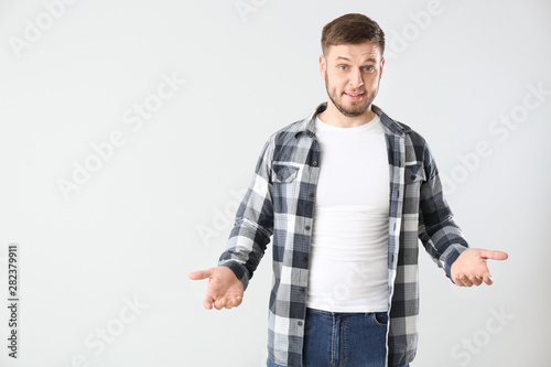Confused young man on light...