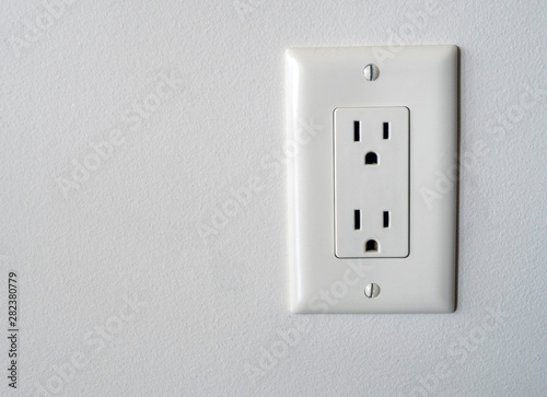 Isolated North American power outlet plug in socket on a white wall background Type B style photo