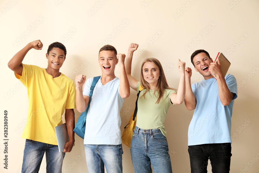 Fototapeta premium Portrait of happy young students on light background
