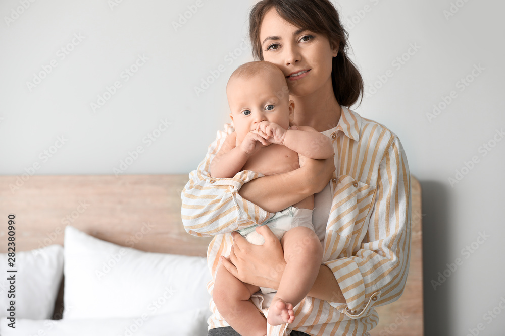 Happy mother with cute little baby at home