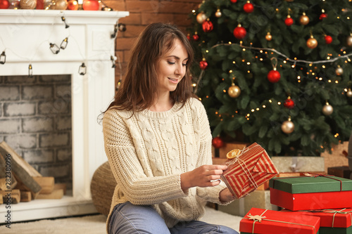 Young woman opening christm...