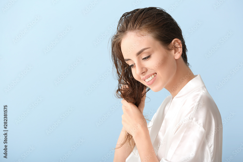 Beautiful young woman after washing hair against color background Beautiful young woman after washing hair against color background