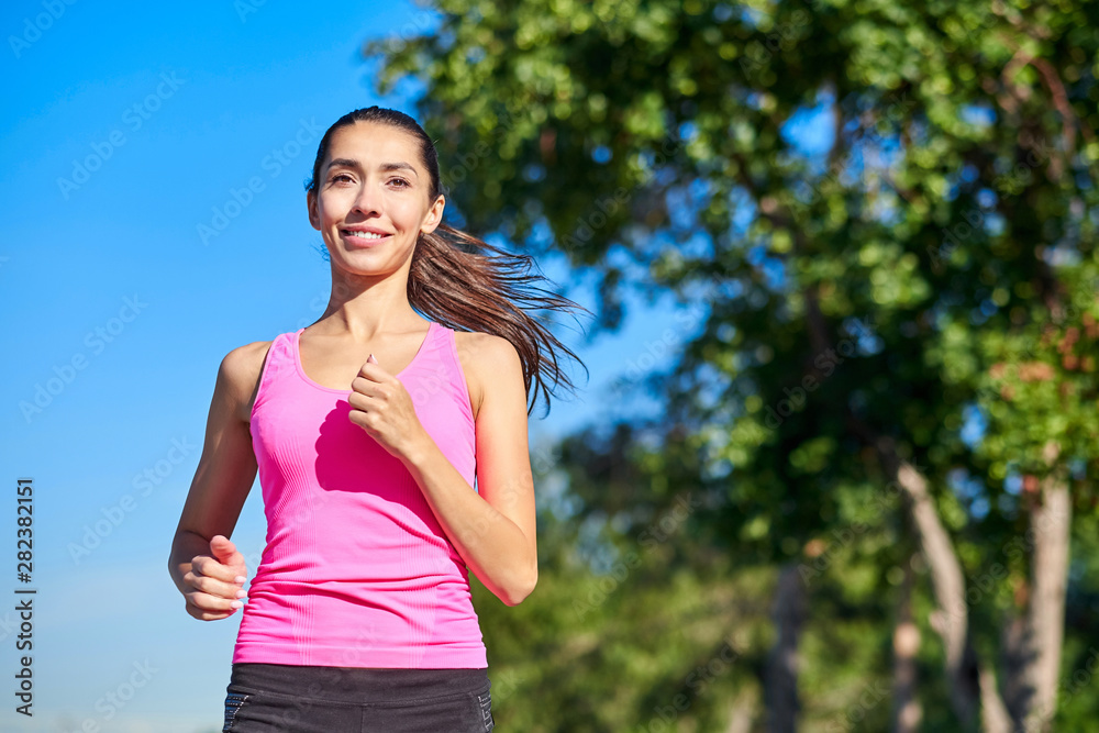 Young fitness woman running at forest trail. Young fitness woman running at forest trail.