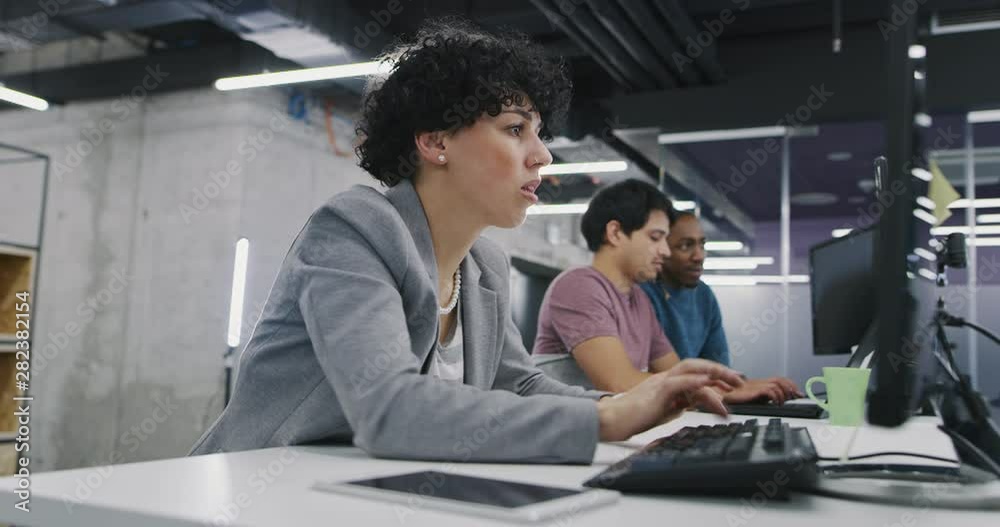 Young multiethnic business team of software developers working together using