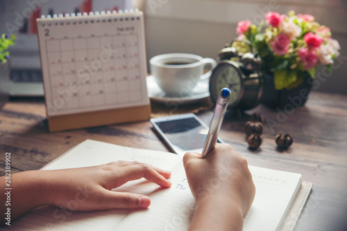 Work online at home, On Diary book, Man hand planner or organizer writing daily appointment, mark and noted schedule (meeting) on book or diary at office desk. Planner concept