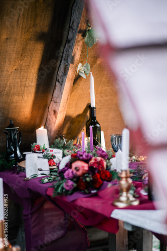 Delicate wedding white cake decorated with pomegranate and succulent surrounded by flowers and candles. photo