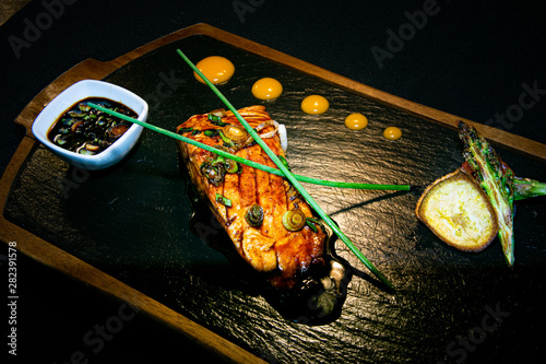 Fototapeta Naklejka Na Ścianę i Meble -  a fillet of Canadian salmon cooked in a teriyaki sauce served with extra sticky sauce and grilled vegetables 