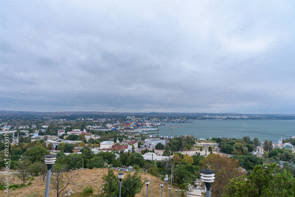 Kerch city and port from the height of the observation deck, in cloudy weather with clouds in the sky.