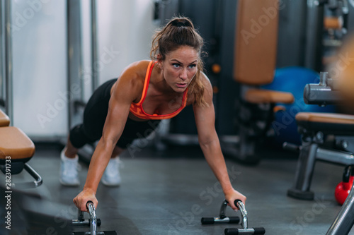 Fototapeta Naklejka Na Ścianę i Meble -  Female Athlete Doing Push-Ups in The Gym
