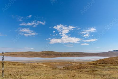 Koyashsky, salty, lake on a sunny day with clouds on the sky, shot during the season of golden autumn. Yellow-golden brown. © StockAleksey