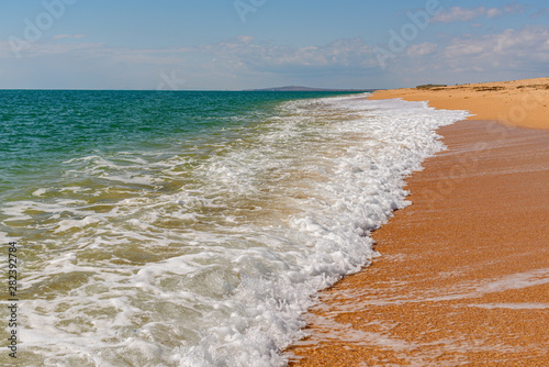 Black Sea coast near the Opuksky nature reserve with bright yellow sand and turquoise water, on a sunny day with clouds on the sky, filmed in the season of golden autumn yellow-golden brown. photo