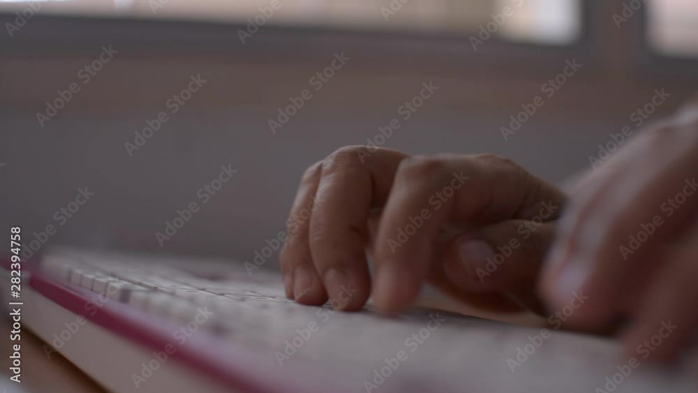 Hands of woman typing on computer keyboard, Businesswoman working on laptop in office, Camera is moving through a cup of coffee. Hands of woman typing on computer keyboard, Businesswoman working on laptop in office, Camera is moving through a cup of coffee.