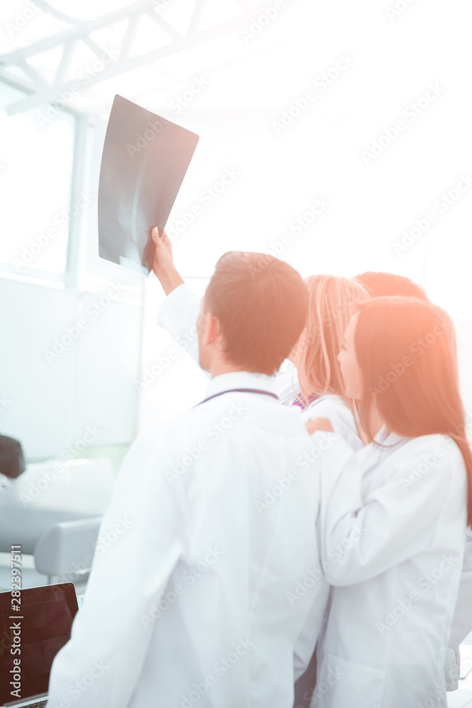 Obraz premium group of doctors surgeons looking at x-ray after surgery