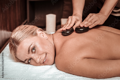 Woman smiling during her hot stone massage.