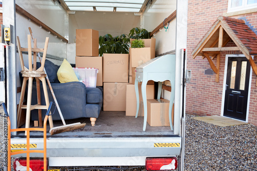 Bild auf Leinwand Removal Truck Waiting To Be Unloaded Outside New Home On Moving Day