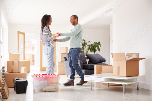 Loving Couple Surrounded By Boxes In New Home On Moving Day © Monkey Business