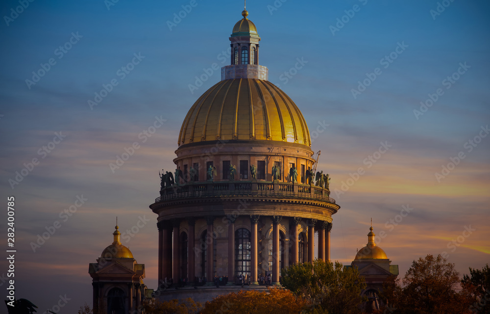 Sunset scene of Golden dome of St Isaac Cathedral over the autumnal garden
