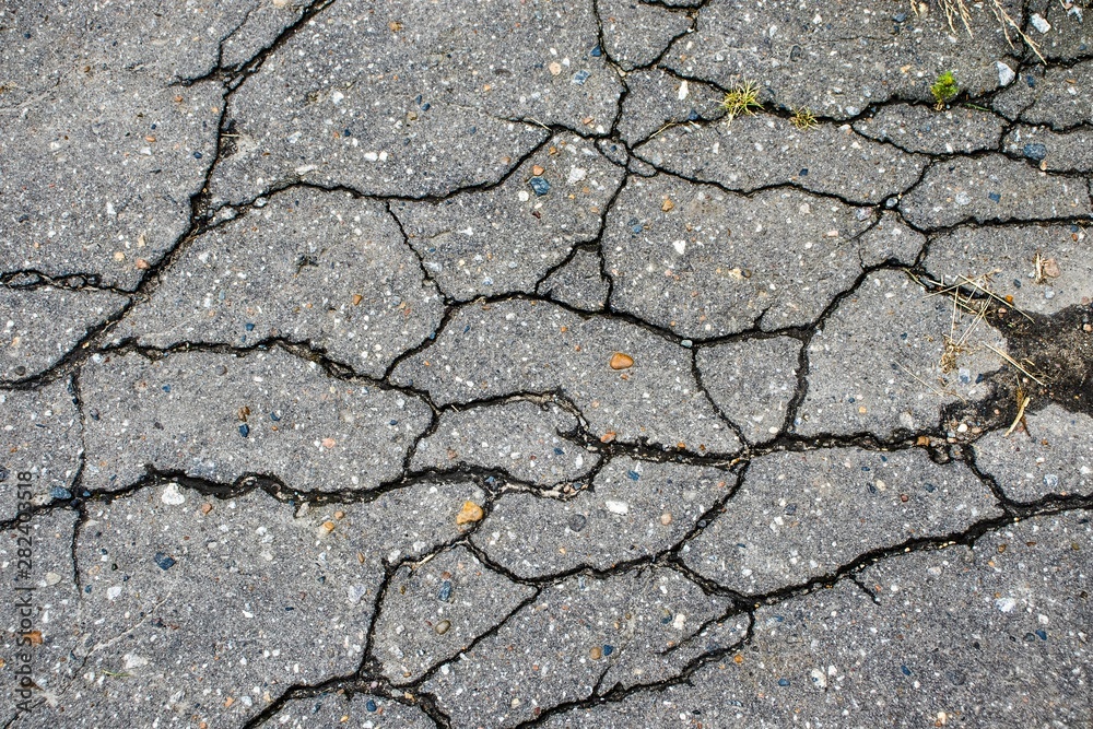 Fototapeta premium Background with old asphalt pavement in cracks