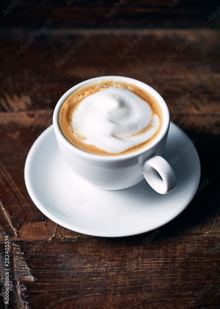 Cup of cappuccino coffee on rustic wooden background Cup of cappuccino coffee on rustic wooden background
