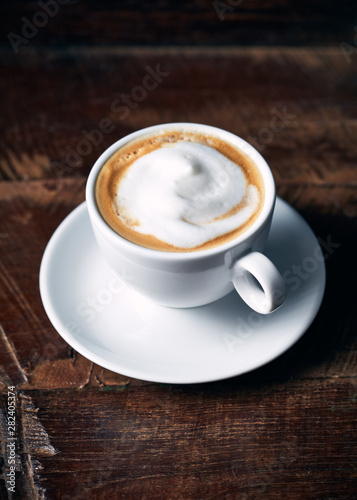 Cup of cappuccino coffee on rustic wooden background