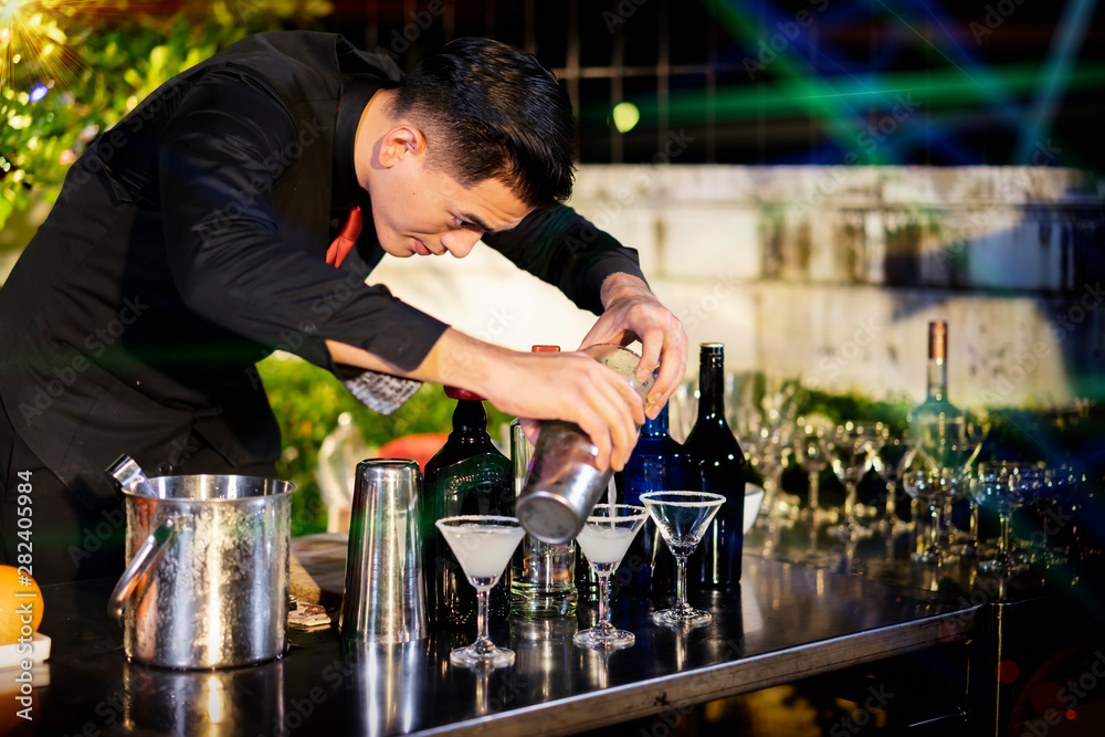 High ISO.The bartender with a cocktail is preparing a cocktail at the bar. Alcoholic beverages, people and luxury concepts.barman making cocktail at nightclub