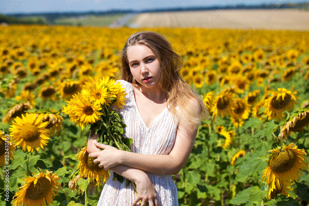 Young beautiful woman in a field of sunflowers Young beautiful woman in a field of sunflowers