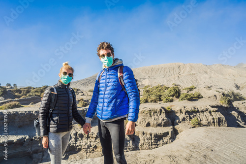 Young couple man and woman visit the Bromo volcano at the Tengger Semeru National Park on Java Island, Indonesia. They enjoy the magnificent view on the Bromo or Gunung Bromo on Indonesian, Semeru and