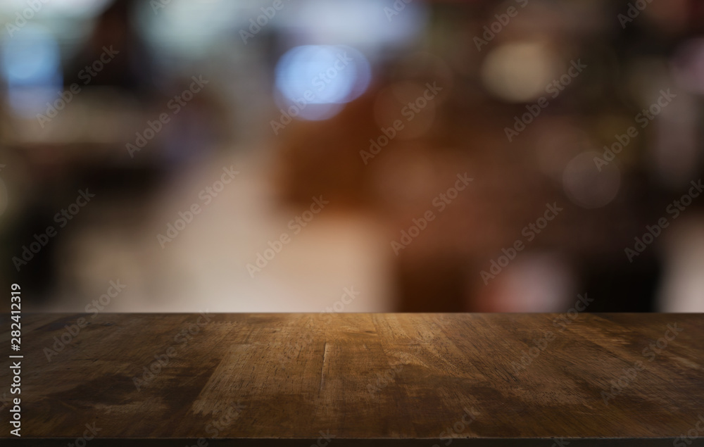 Empty dark wooden table in front of abstract blurred bokeh background of restaurant . can be used for display or montage your products.Mock up for space. Empty dark wooden table in front of abstract blurred bokeh background of restaurant . can be used for display or montage your products.Mock up for space.