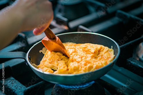 Preparing scrambled eggs in a pan, close-up.
