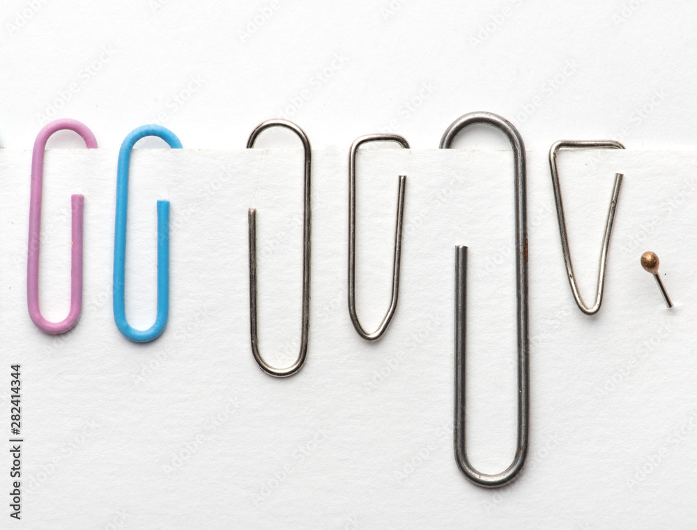 Paper clips hold paper. Needles on white background Paper clips hold paper. Needles on white background
